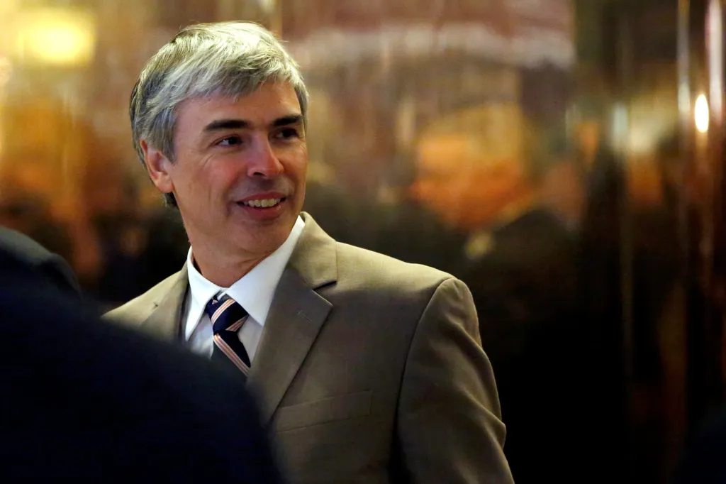 Larry Page, CEO and co-founder of Alphabet, smiling while wearing a suit and striped tie.