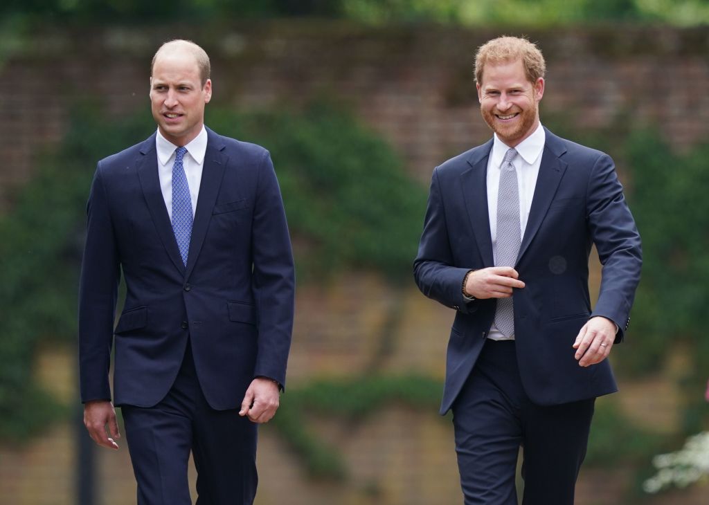 Prince William and Prince Harry walking together, both wearing suits.