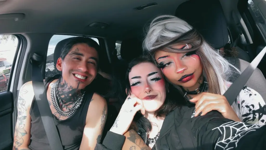 Frank, Lexi, and Tatyana, a polyamorous throuple, smiling for a selfie in a car.