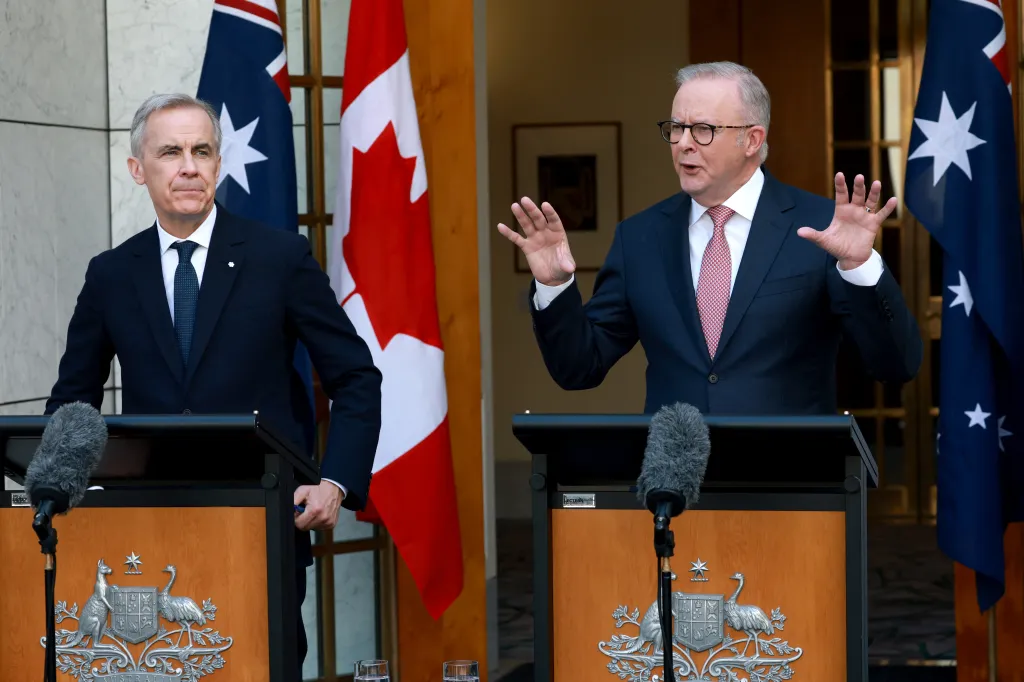 Canada's Prime Minister Mark Carney (L) listens to Australia's Prime Minister Anthony Albanese speak during a press conference at Parliament House in Canberra on March 5, 2026.