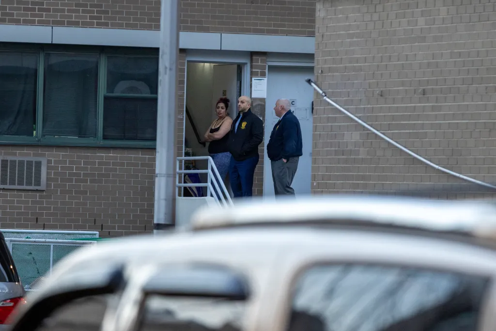 NYPD officers and a woman at the scene of a shooting in Brooklyn.