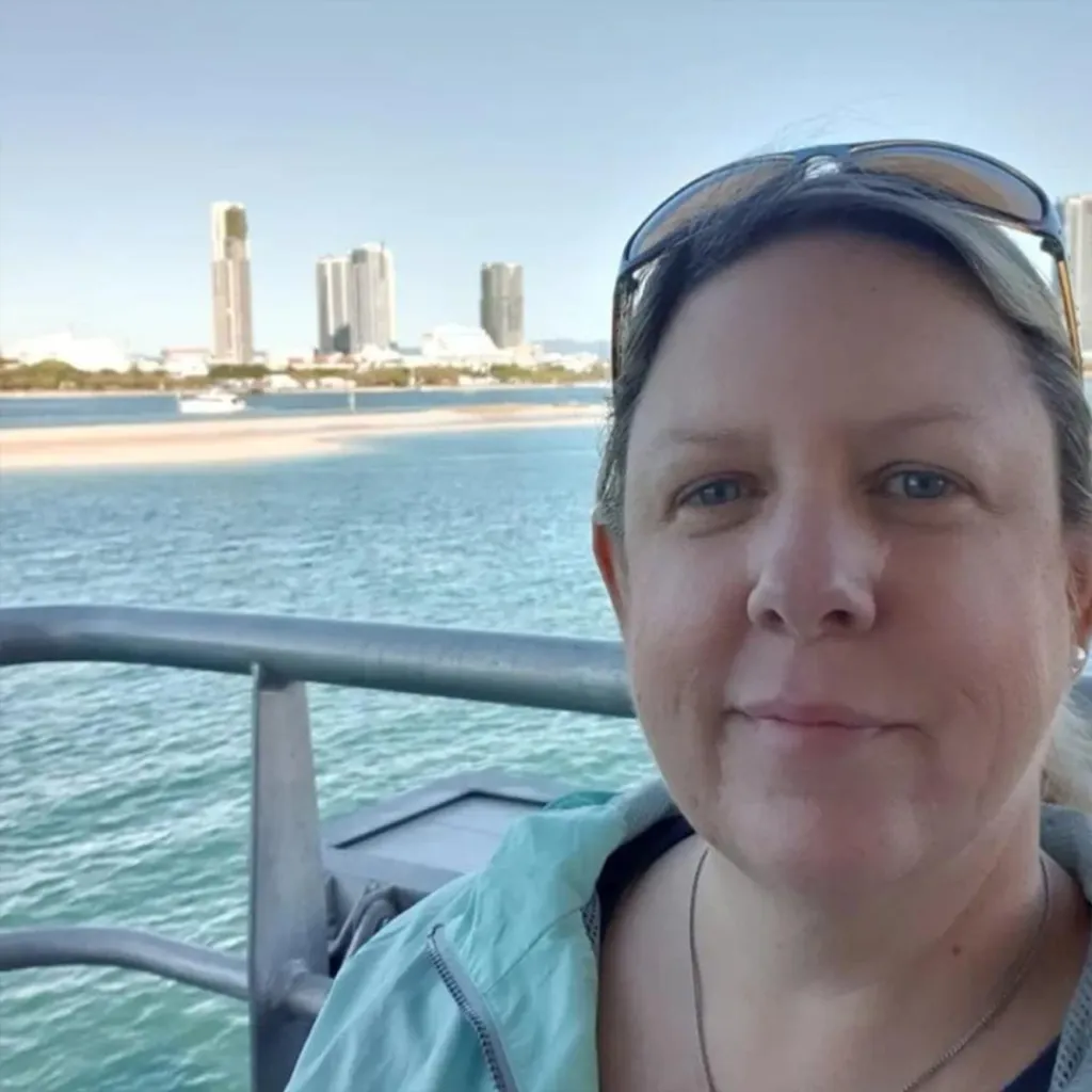 Jodie Daunis, a former Brisbane CityCat staffer, on a ferry with the city skyline in the background.