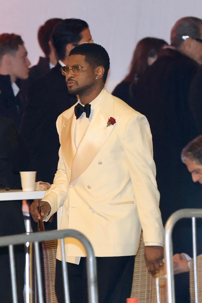 Usher in a cream double-breasted tuxedo with a red rose boutonnière.