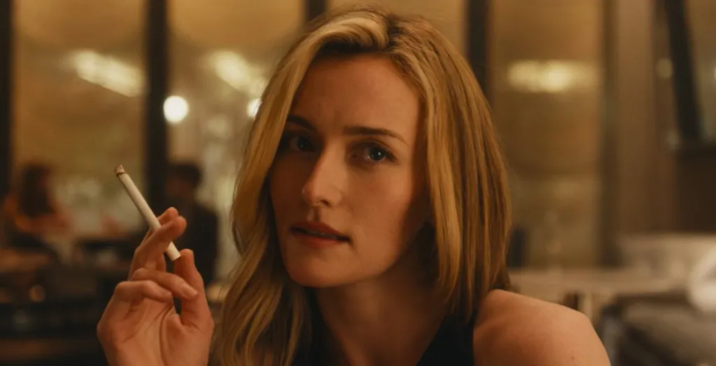 Sarah Pidgeon as Carolyn Bessette, holding a lit cigarette.