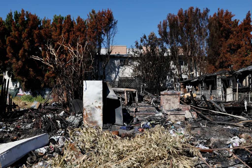 The aftermath of a fire in Larchmont, Los Angeles, showing the debris and charred remains of a property where squatters had been living.