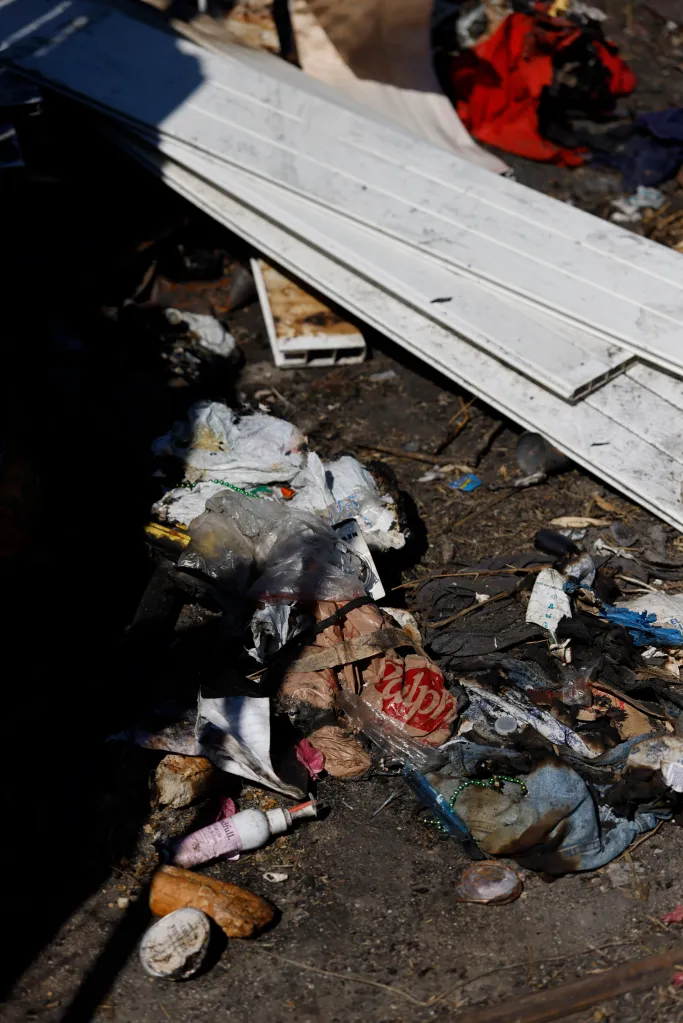 Trash, including burnt items and debris, on the ground of the property adjacent to the Galicia home in Larchmont.