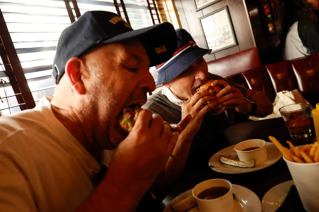 Simon Dominguez and Scott Northeimer biting into French Dips at Cole's French Dip.