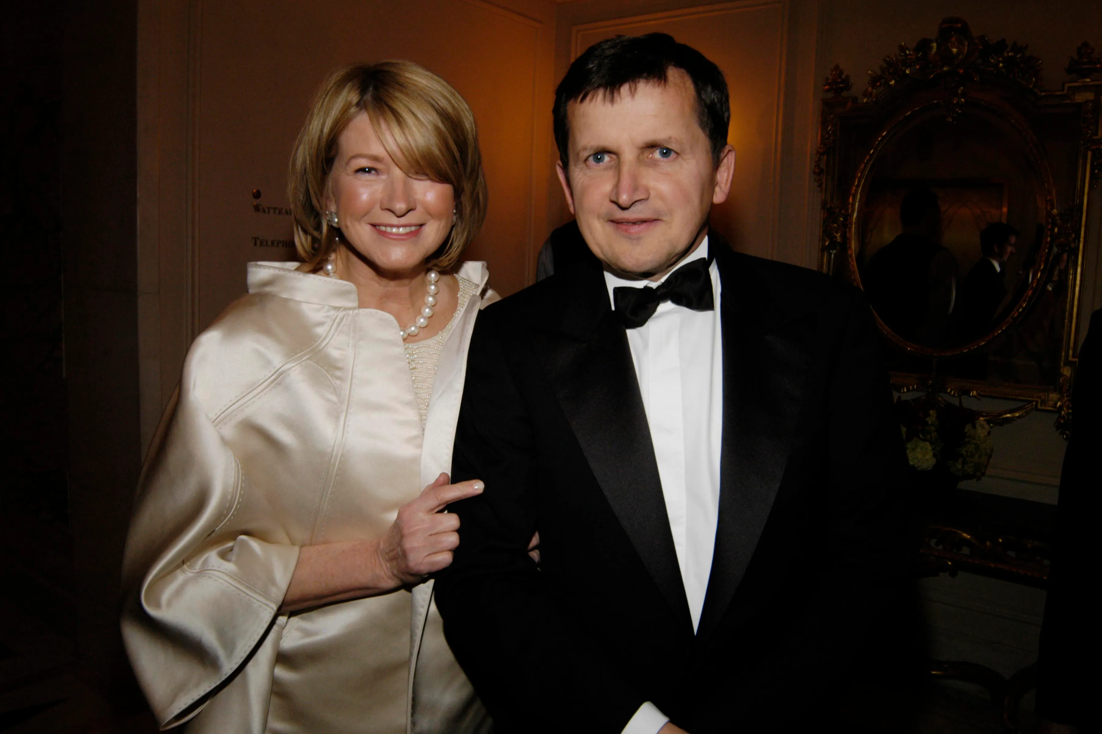 Martha Stewart in an ivory coat and pearls with Charles Simonyi in a tuxedo at a gala.