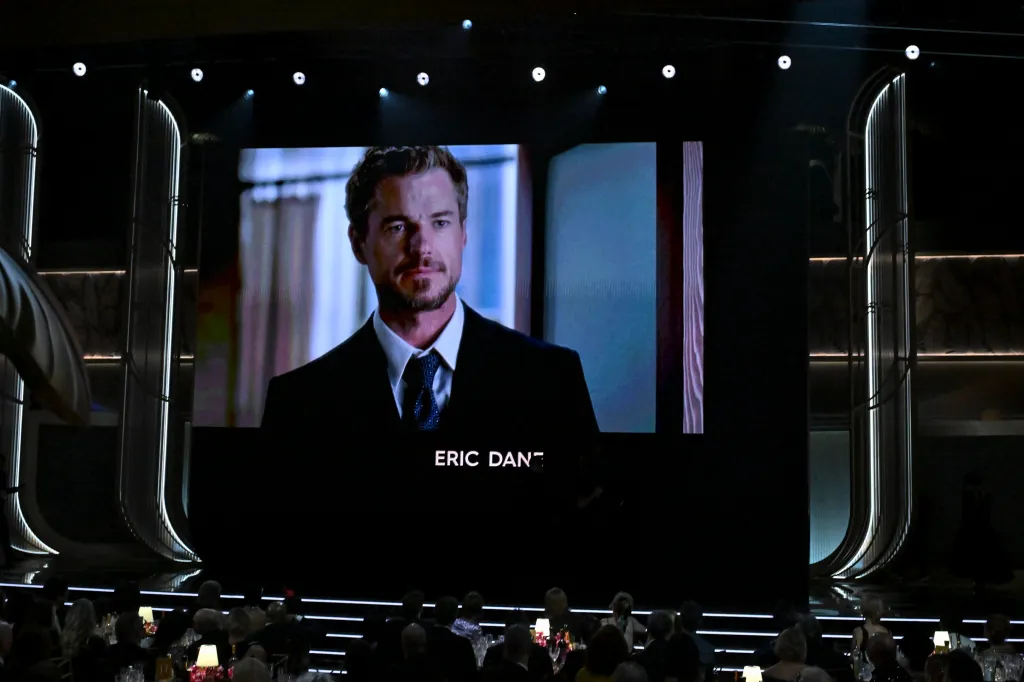 A memorial presentation honoring Eric Dane plays on a large screen at an awards show.