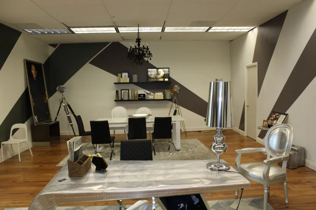 Merabi Professional Medical Plaza office interior with a white dining table, black chairs, and a silver riveted desk in the foreground.