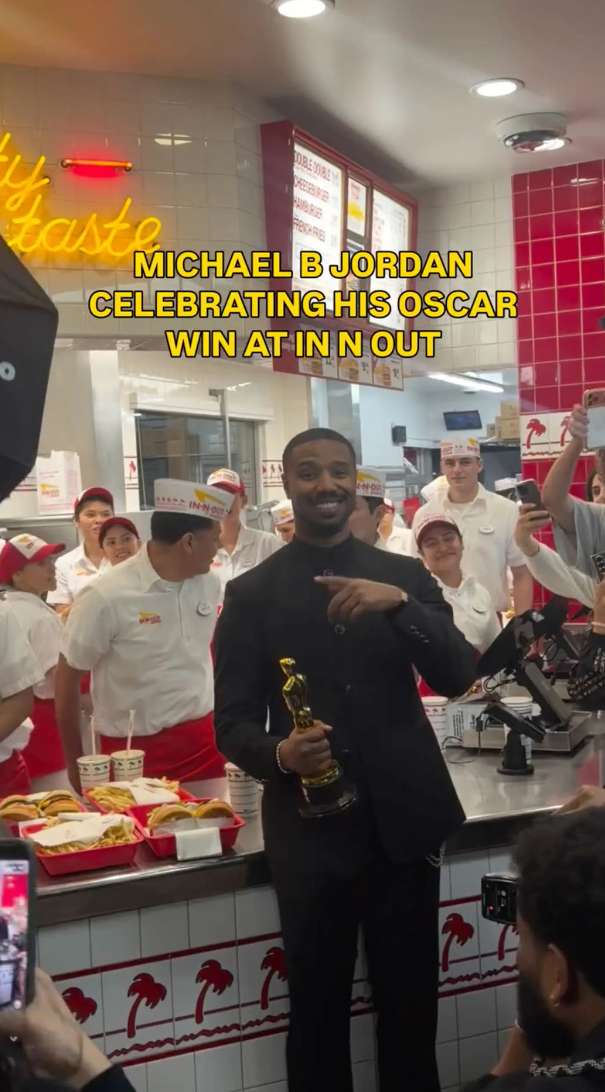 Michael B. Jordan holding an Oscar in an In-N-Out restaurant.