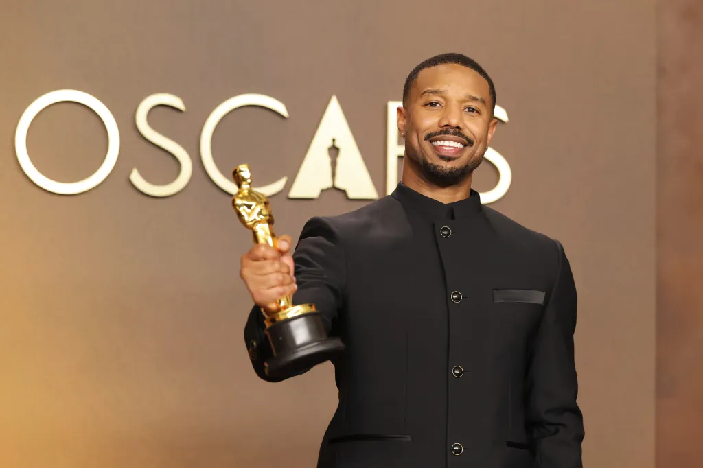 Michael B. Jordan smiles holding his Best Actor Oscar.