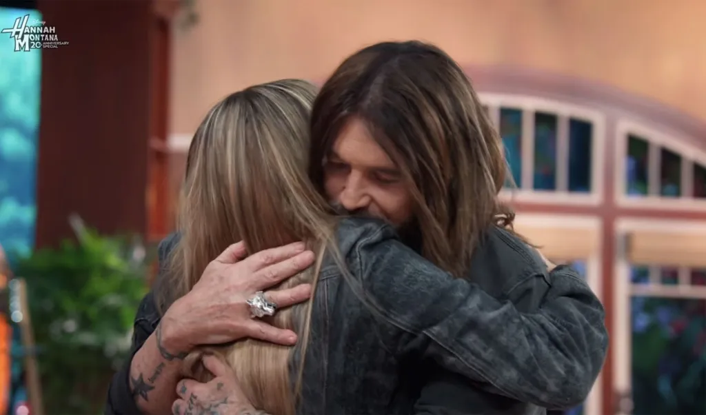 Miley Cyrus and Billy Ray Cyrus hugging.