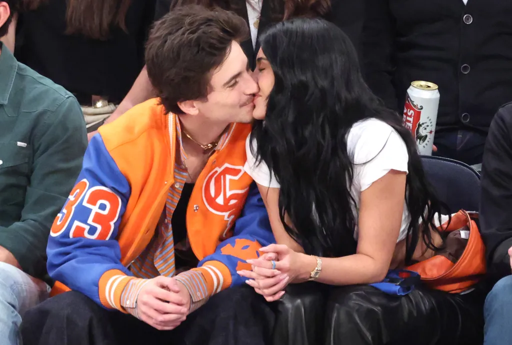 Timothee Chalamet kisses Kylie Jenner while sitting courtside at an NBA game.