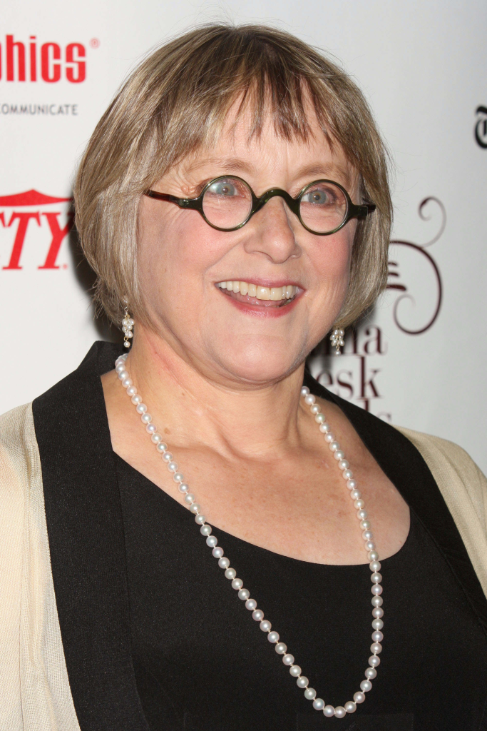 Mary Beth Hurt in a black top with an off-white shawl and a pearl necklace, smiling.