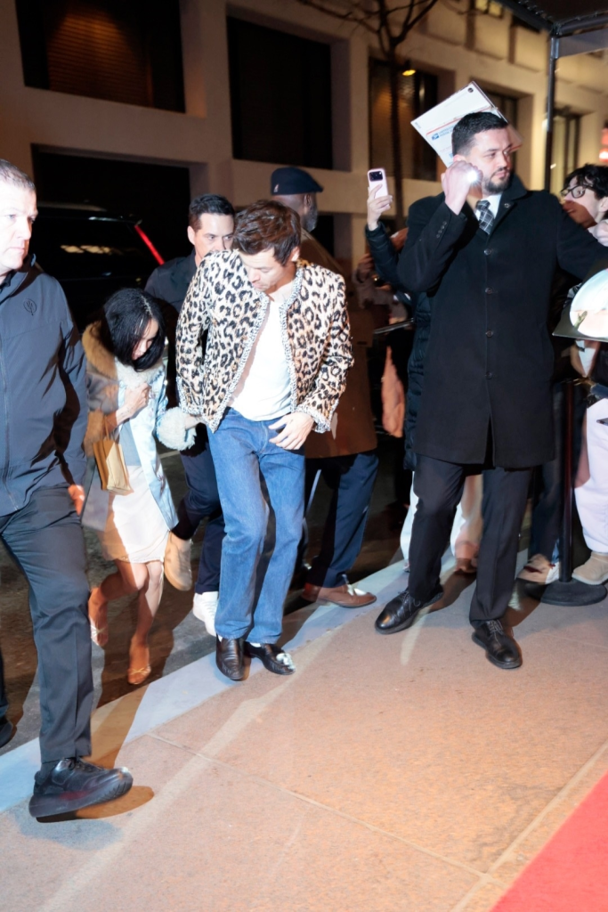 Harry Styles in a leopard print jacket and jeans surrounded by a crowd at the SNL afterparty.