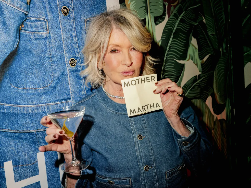 Martha Stewart holding a drink and a 