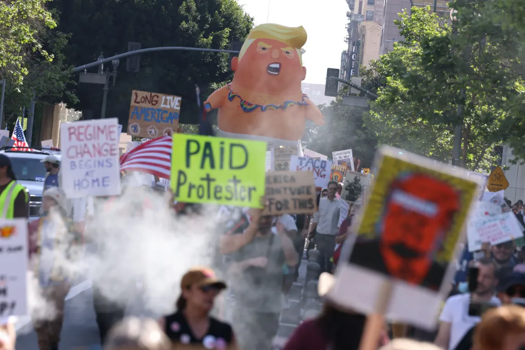 Protesters hold signs including