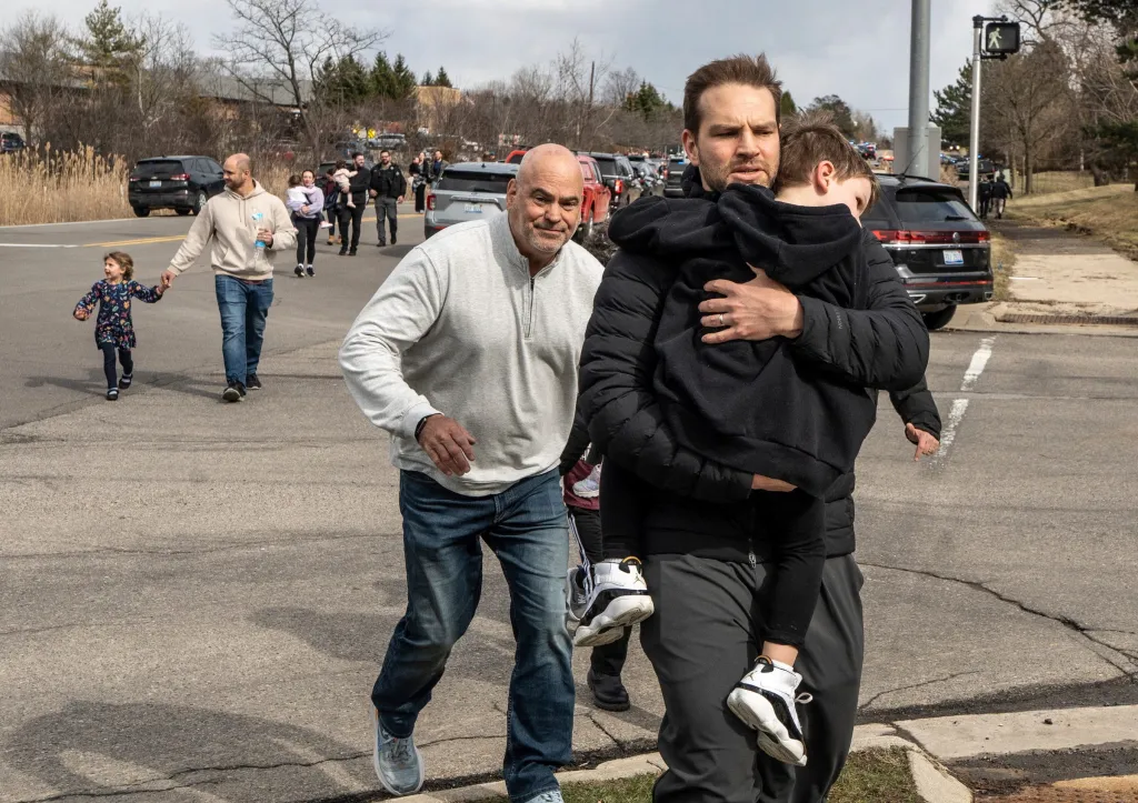 Parents escort their children away from Temple Israel synagogue after a truck crashed into the building.