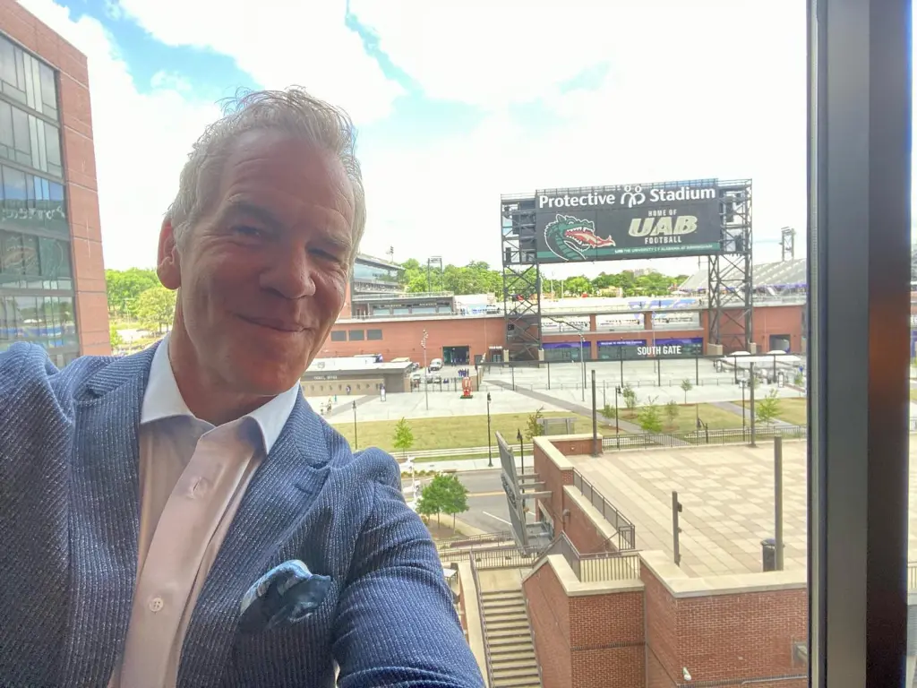 Paul Burmeister taking a selfie with Protective Stadium in the background.