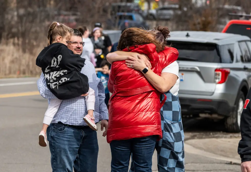 People embrace as children are picked up from the scene near Temple Israel in West Bloomfield on Thursday, March 12, 2026, where a man drove his vehicle into the building.