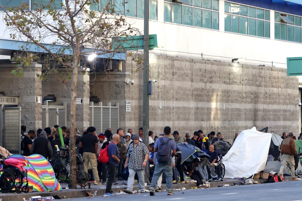 People line up for services outside The Midnight Mission homeless shelter on Skid Row in Los Angeles.