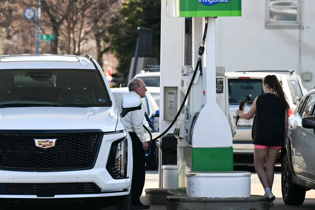 People pump gas at a station in Washington, D.C.