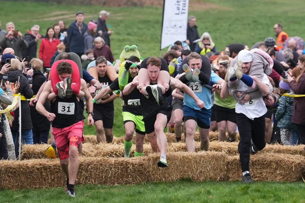 People take part in the annual UK Wife Carrying Race in Dorking, England, Sunday March 8, 2026.