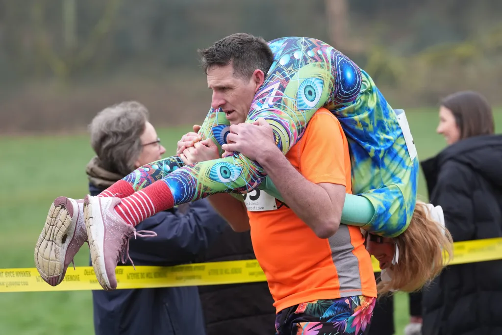 Wives and girlfriends clung on for dear life as their partners carried them up and down a hillside for the UK Wife Carrying Race, one of the country's quirkiest annual sports events.