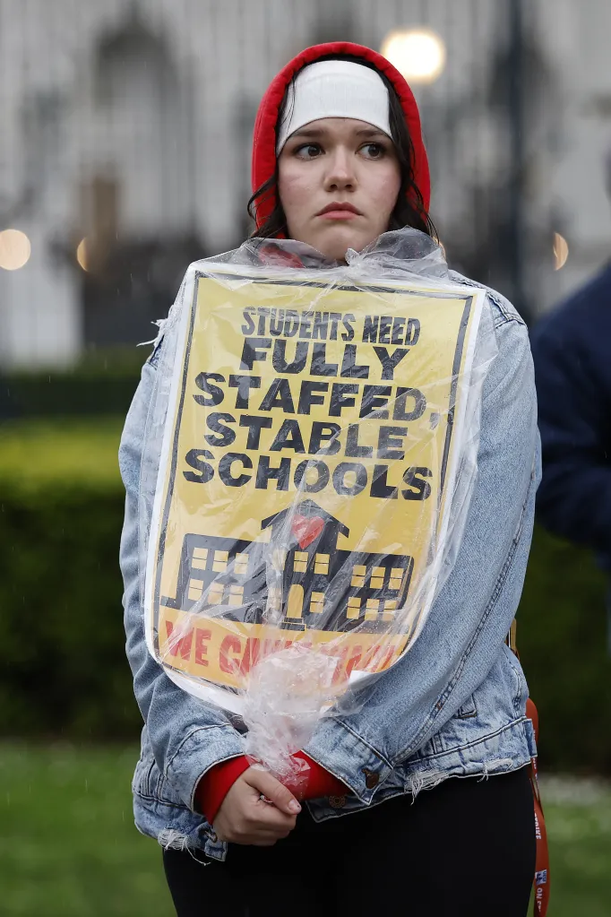 A person holding a sign that reads 