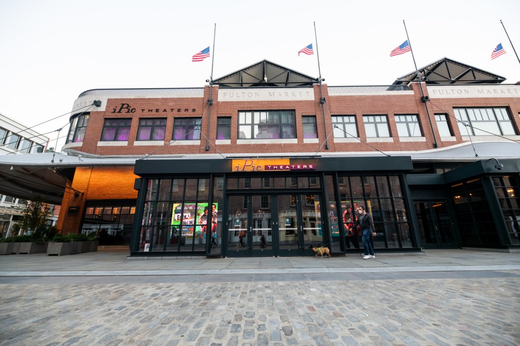 A person walking a dog outside iPic Theaters in Fulton Market, with 