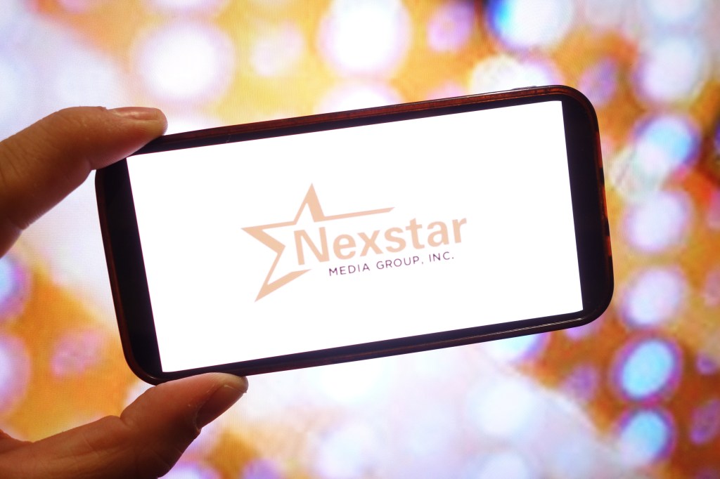 Illustration of the Nexstar Media Group logo displayed on a smartphone screen.