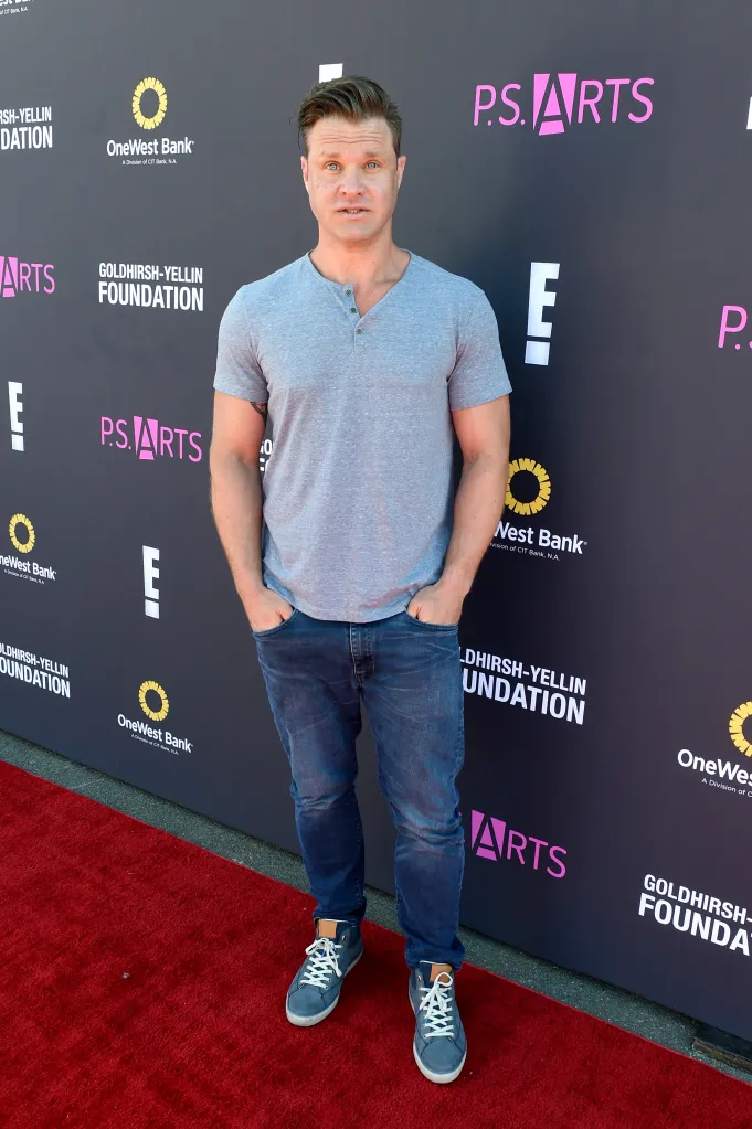 Actor Zachery Ty Bryan stands on a red carpet.