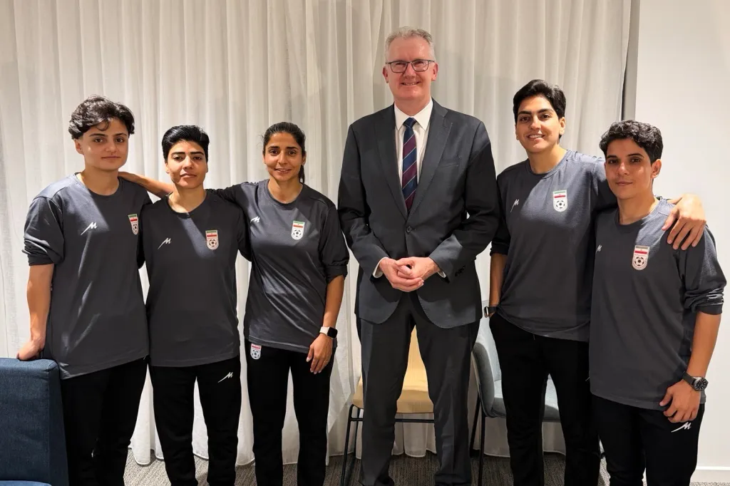 Australia's Minister for Home Affairs Tony Burke posing with five Iranian women soccer players who have been granted asylum.