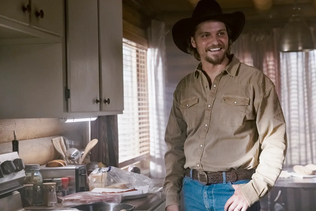 Luke Grimes as Kayce Dutton smiling in a kitchen.