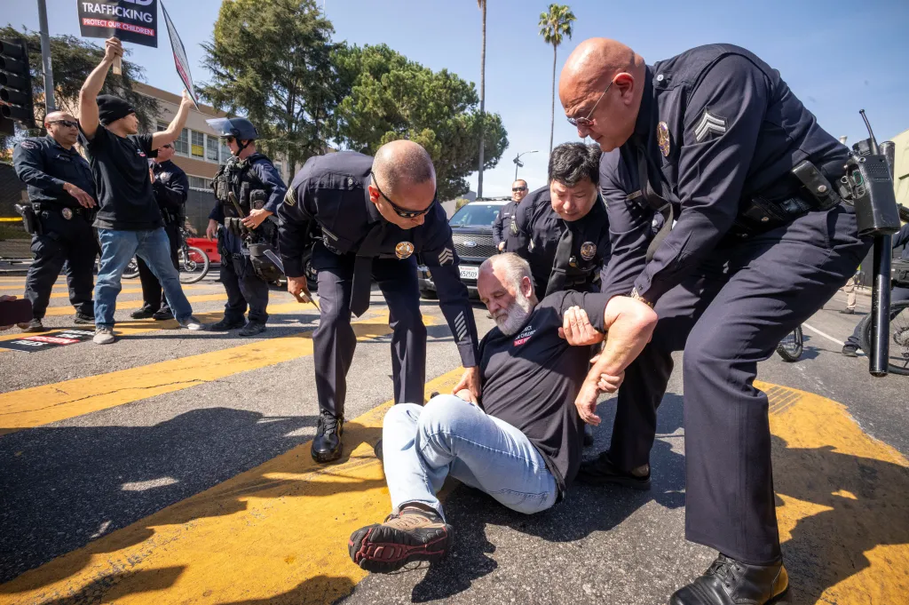 Police officers remove a sit-in protester outside the 98th annual Academy Awards in Los Angeles.