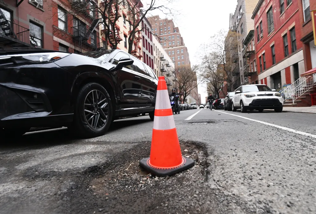 A traffic cone sitting in a pothole on W. 16th St. in Manhattan on March 13, 2026.