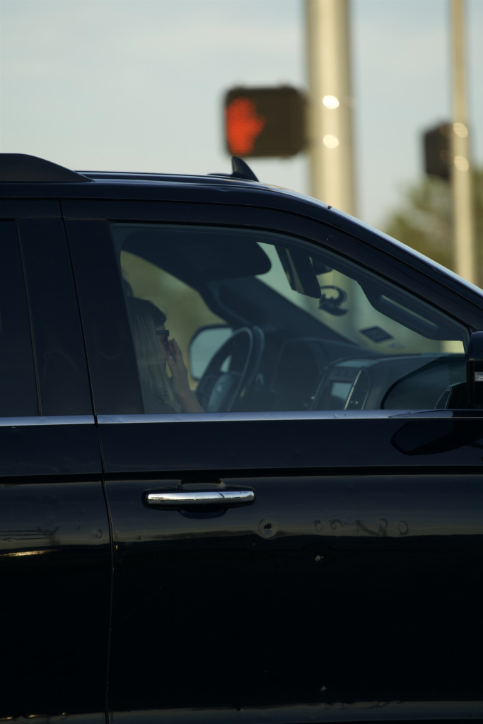 Kendra Duggar in a black car with a blurred background.