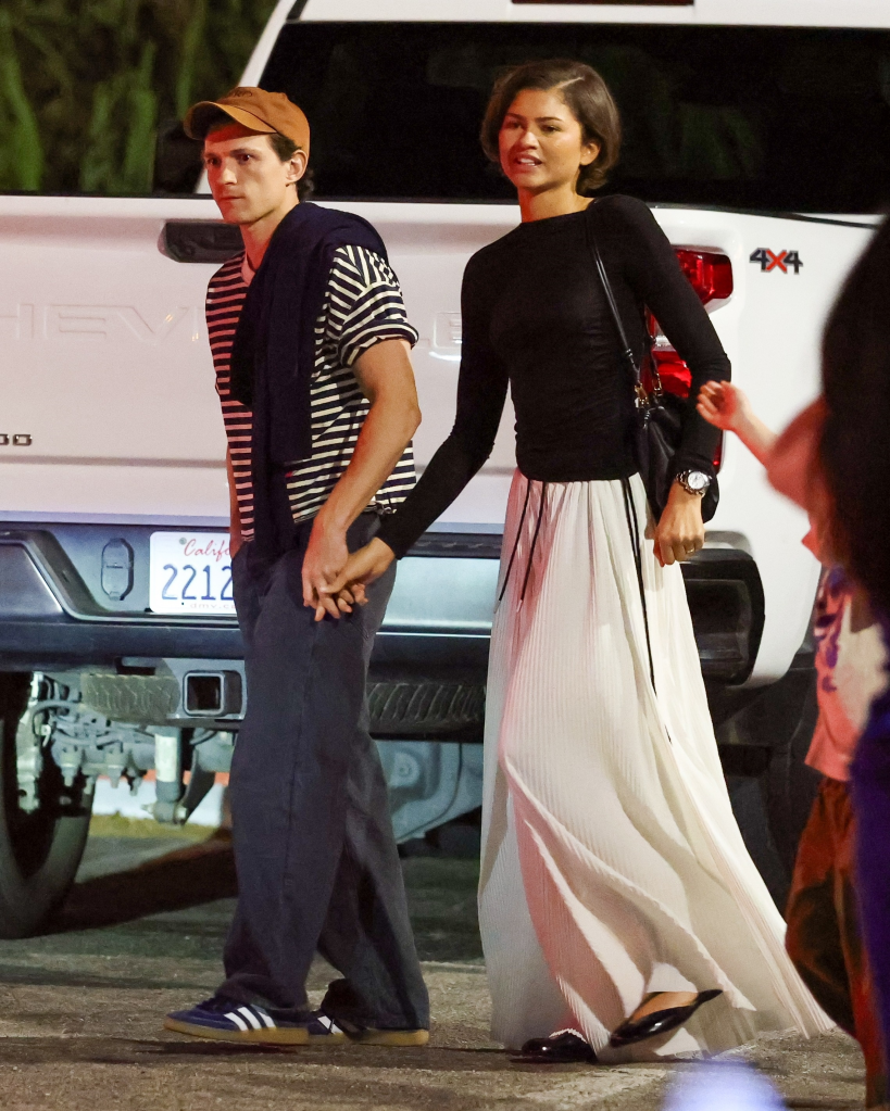 Zendaya and Tom Holland holding hands during a dinner outing in Los Angeles.