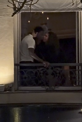 Damson Idris and Lori Harvey kissing on a balcony at an after-party in Paris.