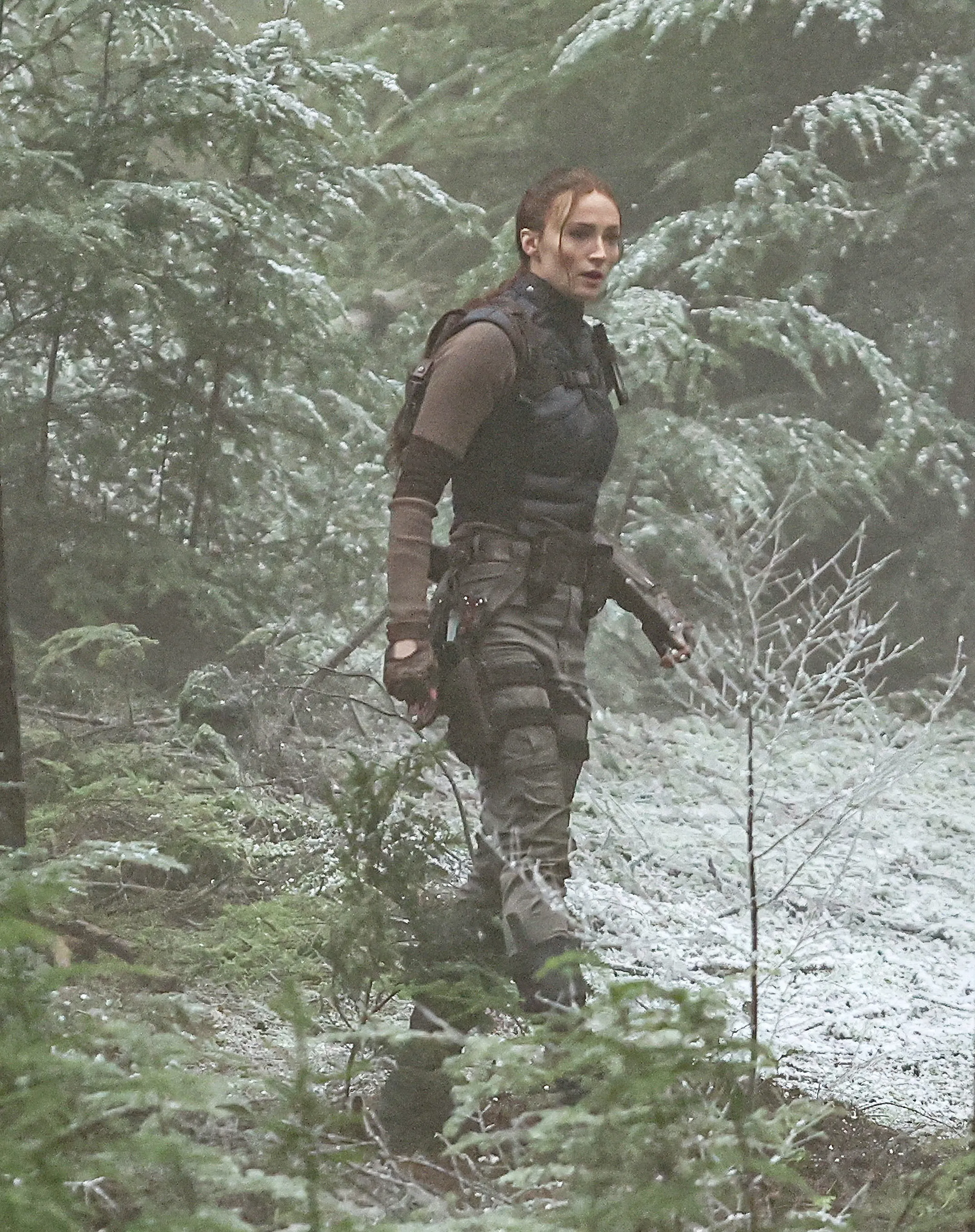 Sophie Turner as Lara Croft in a snowy forest.