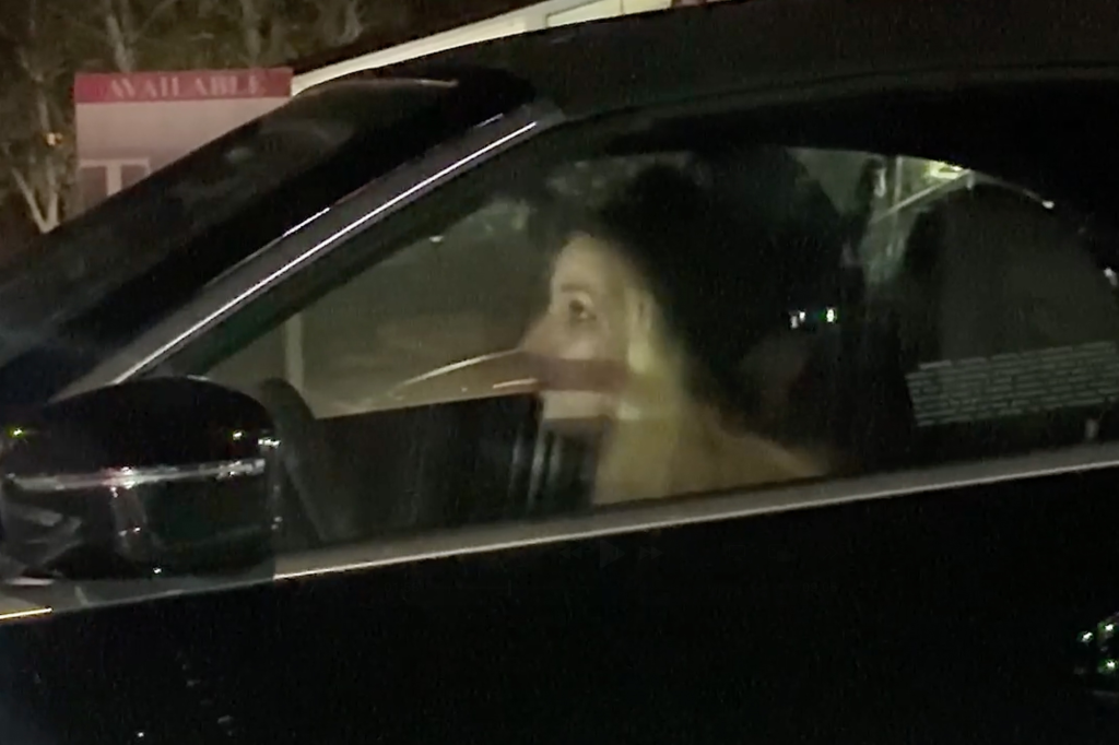 Britney Spears looking out the window from the driver's seat of her car.