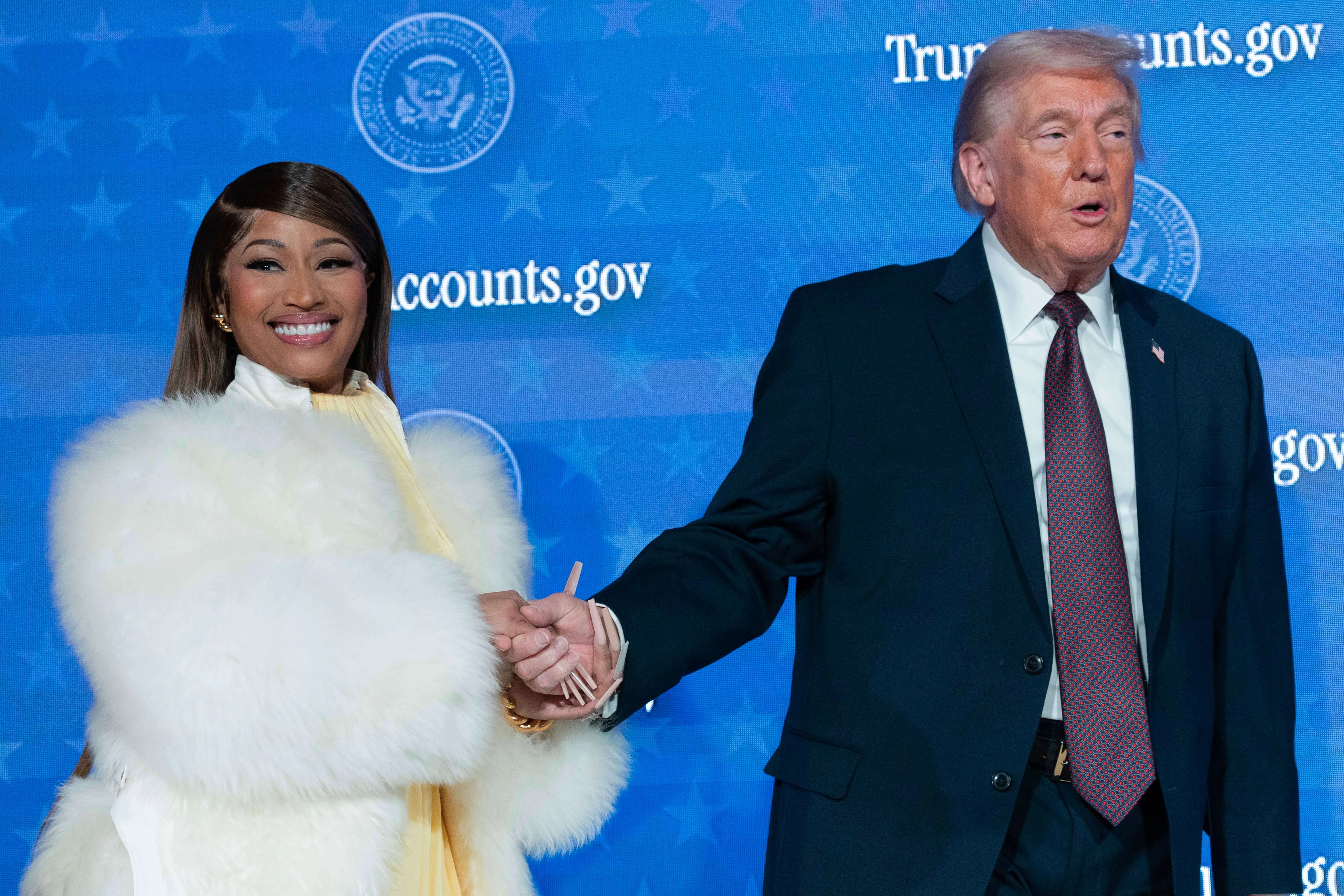 Donald Trump and Nicki Minaj shaking hands at a podium.