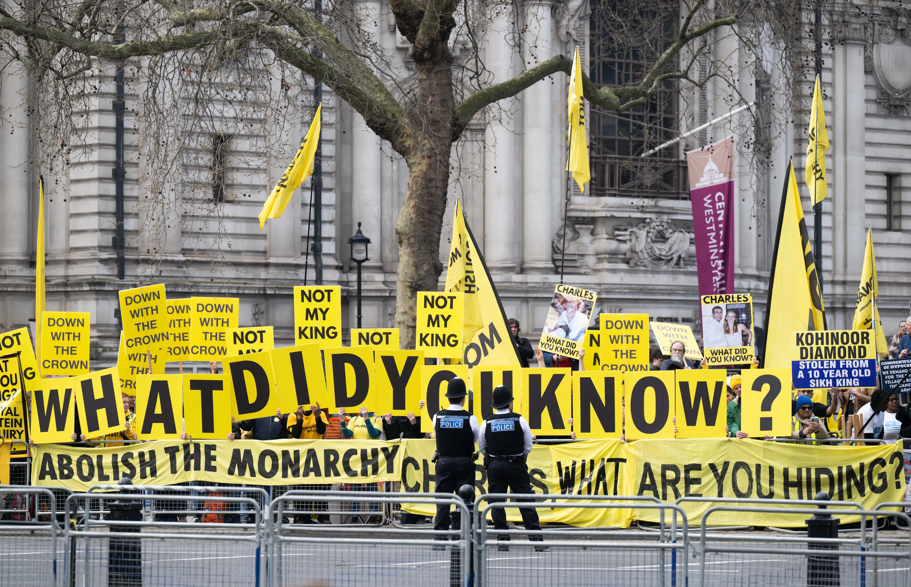 Protesters with yellow signs reading 