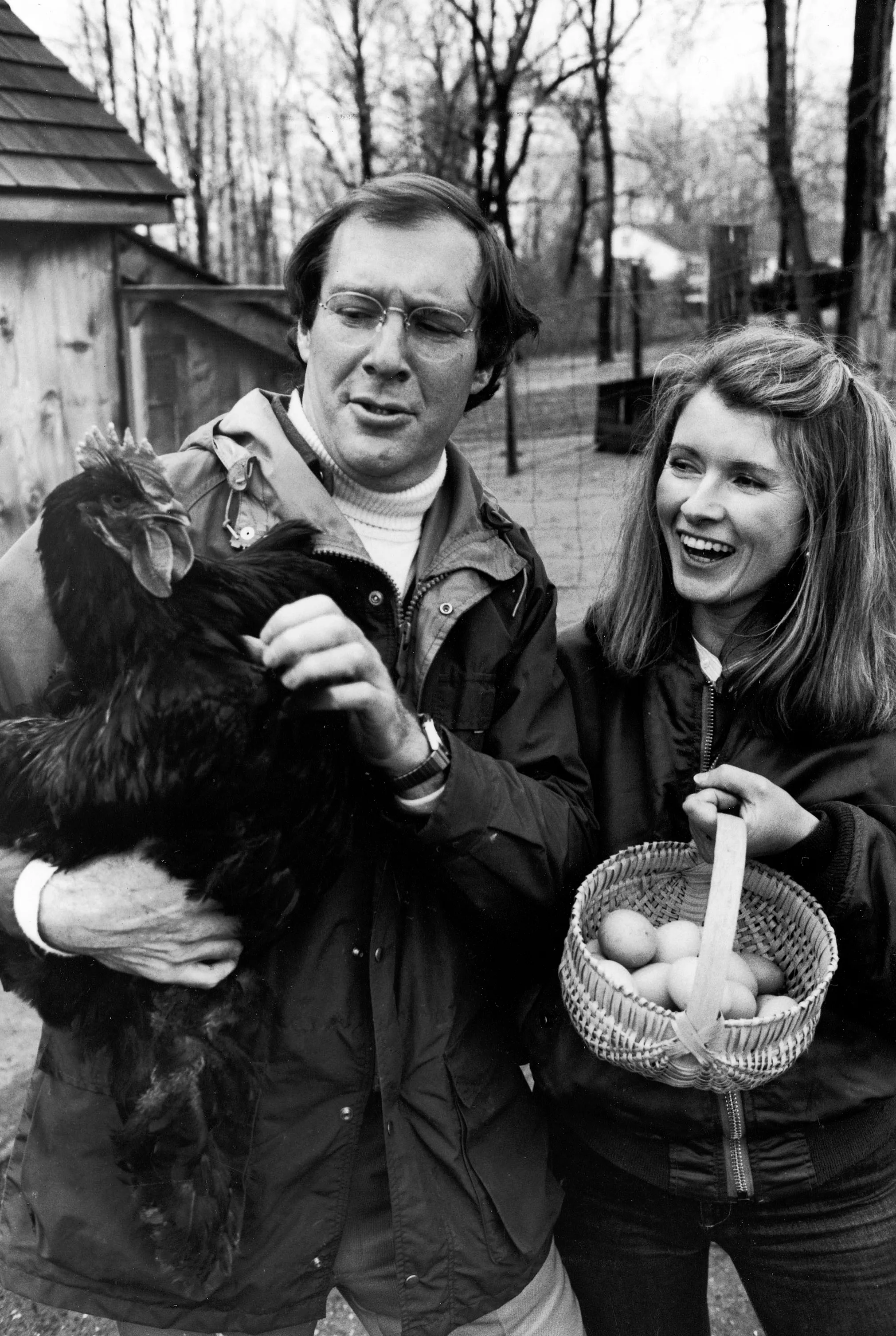Publisher Andy Stewart holding a black Cochin hen and wife, caterer Martha, holding a basket of eggs.
