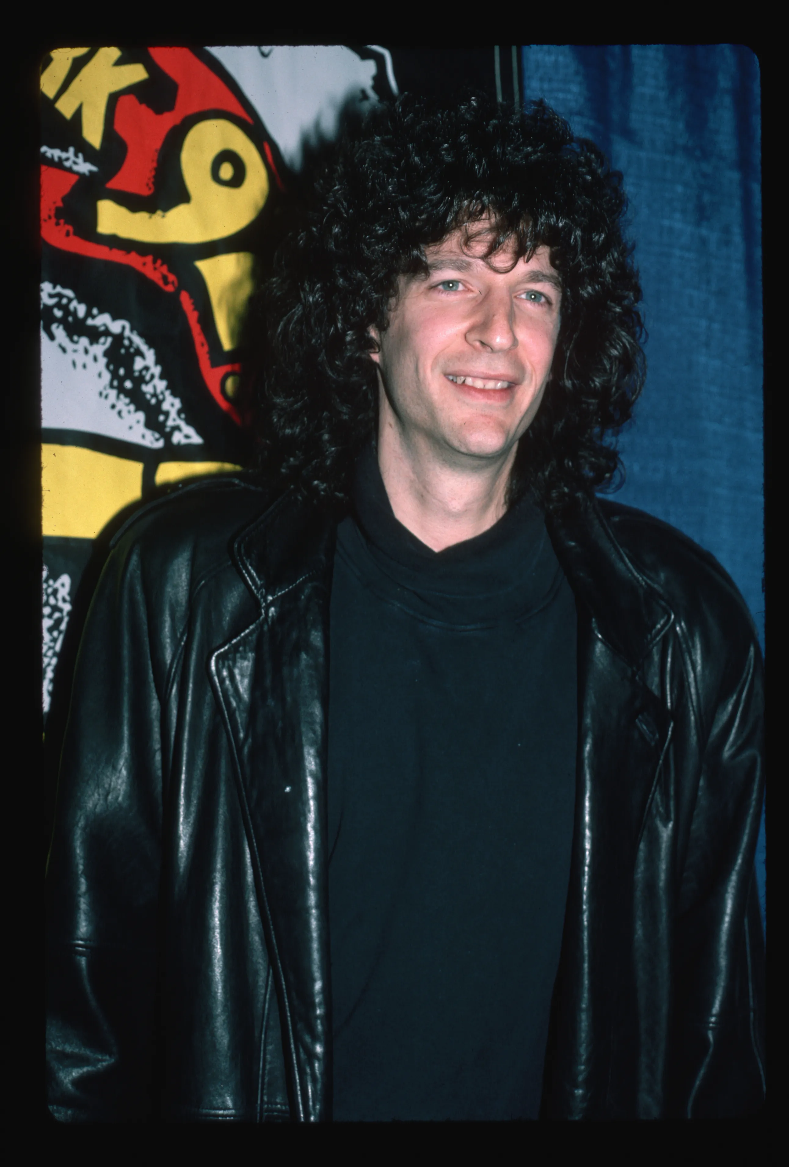 Radio talk show host Howard Stern wearing a black turtleneck and leather jacket.