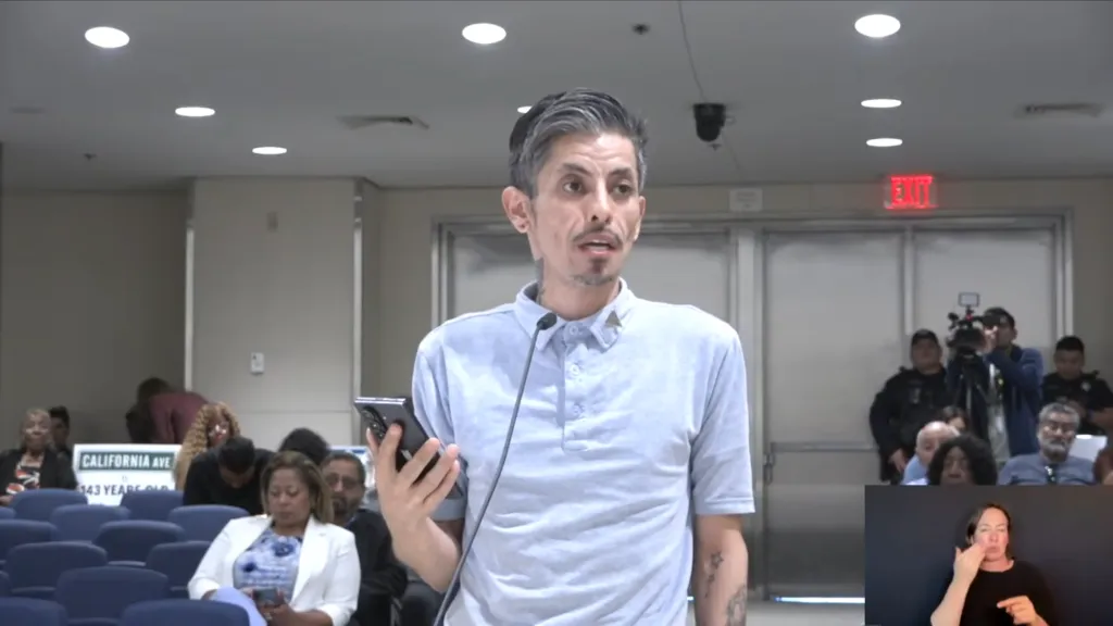 Rene Campos speaking at a podium with an American Sign Language interpreter inset.