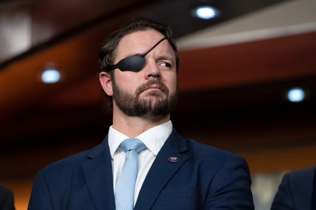 Rep. Dan Crenshaw, a Navy SEAL veteran who wears an eye patch, looks right with a serious expression.