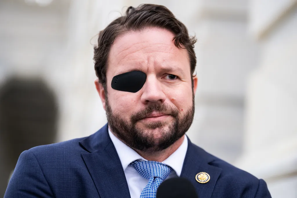 Rep. Dan Crenshaw, R-Texas, talks with reporters outside the U.S. Capitol.
