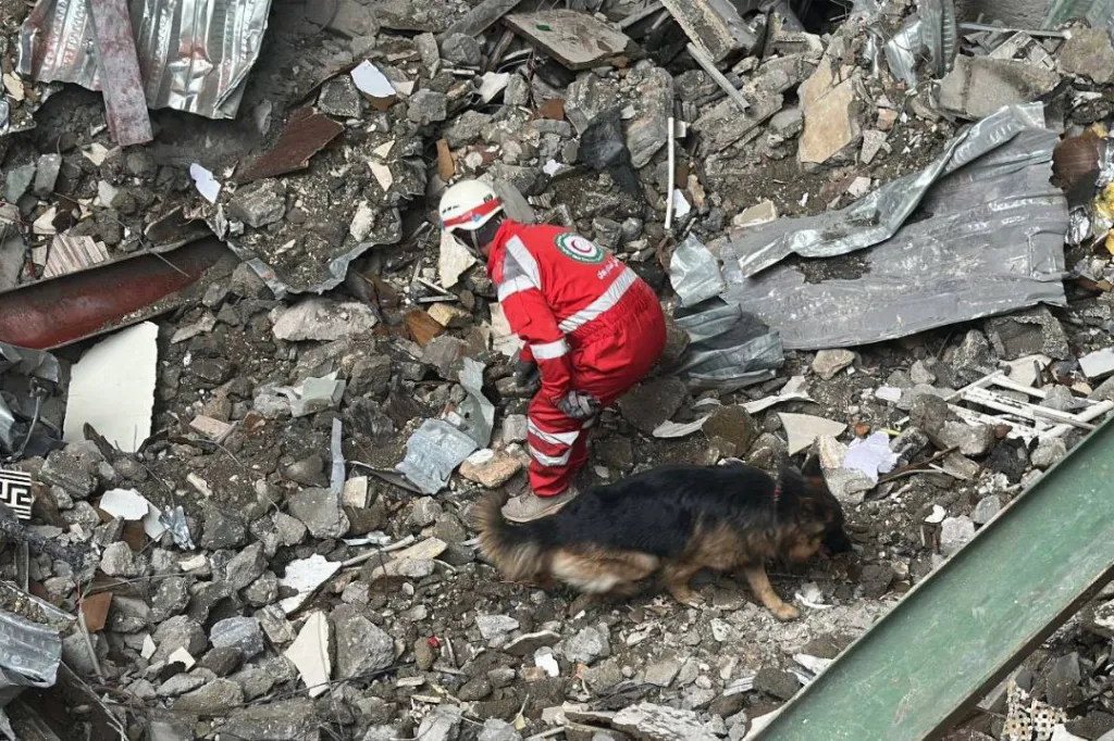 An Iranian Red Crescent worker searches through the rubble of a building after an airstrike in Tehran on March 7, 2026.